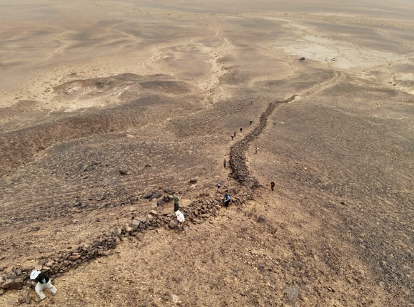 Aerial drone photograph showing the preserved stone section of the Gobi Wall traversing the hillside. Image credit: Golan et al., doi: 10.3390/land14051087.
