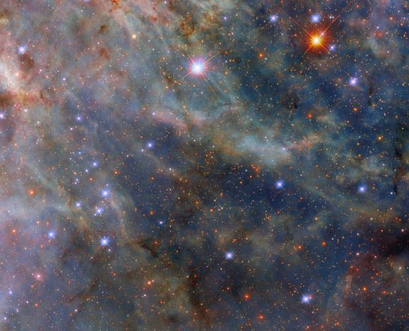 This Hubble image shows part of the Tarantula Nebula, a star-forming region some 163,000 light-years away in the constellation of Dorado. The color image is a composite of separate exposures acquired by Hubble’s Wide Field Camera 3 (WFC3) instrument in the ultraviolet, near-infrared, and optical parts of the spectrum. It is based on data obtained through four filters. The color results from assigning different hues to each monochromatic image associated with an individual filter. Image credit: NASA / ESA / Hubble / C. Murray.
