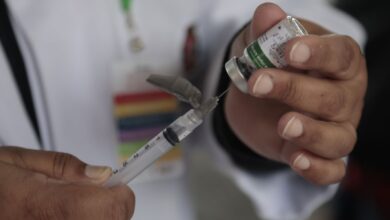 Profissional de saúde com máscara e emblema do MS. Foco na vigilância da Influenza no SUS.