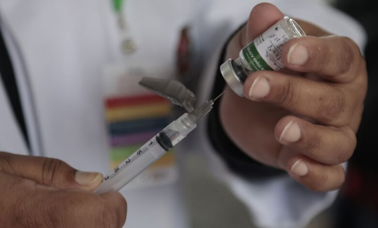 Profissional de saúde com máscara e emblema do MS. Foco na vigilância da Influenza no SUS.